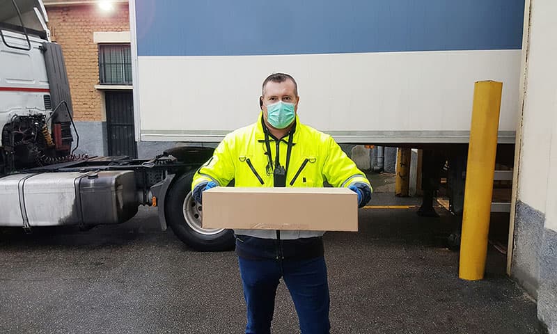 Doručovatel s rouškou a balíkem